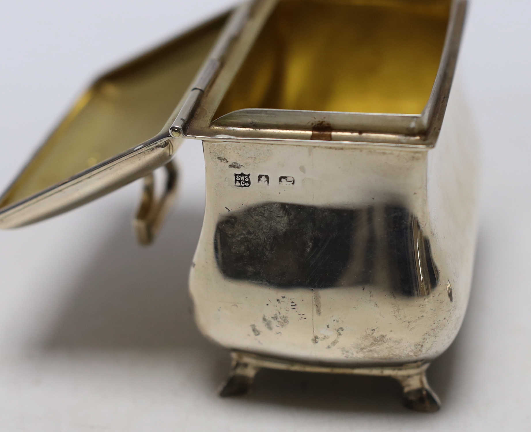 A George V silver bombe shaped tea caddy, S.W. Smith & Co, Birmingham, 1916, width 9cm, together with a later silver caddy spoon.